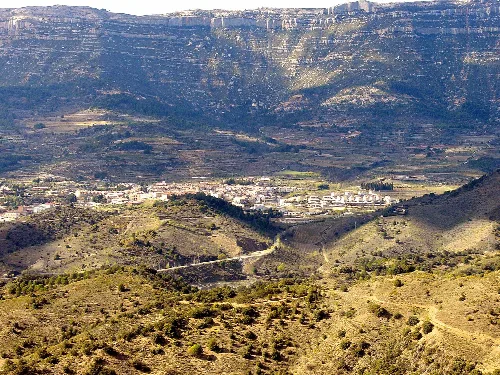 Paisaje con montañas y pueblo en un valle amplio.