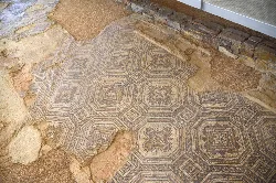 Mosaico romano con patrones geométricos y motivos florales en la Villa Romana Orpheus de Camarzana de Tera