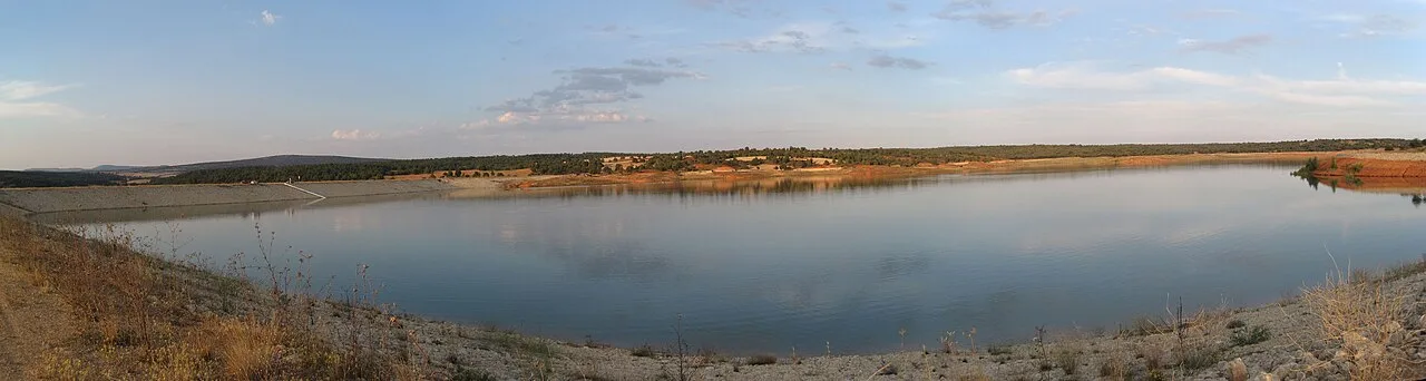 Panoramic view of Arauzo de Salce reservoir with water and clear sky.