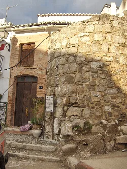 Runder Steinturm neben einem Haus in Alozaina.