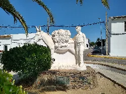 Skulptur eines Mannes, eines Esels und einer Palme in Castilblanco de los Arroyos.