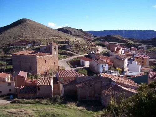 View of houses and a stone building in a mountain village.