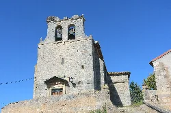 Torre de piedra de la iglesia con campanas y cielo azul.