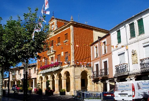 Main square with brick building and arches in Herrera de Pisuerga.