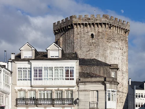 Turm der Os Andrade und moderne Gebäude in Vilalba, Galicien.