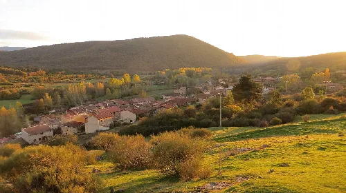 Autumn landscape with houses, trees, and mountains in Barbadillo de Herreros.