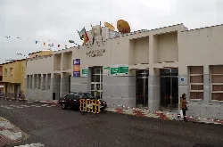 Edificio del Palacio de la Cultura en Calamonte con banderas y personas en la acera.