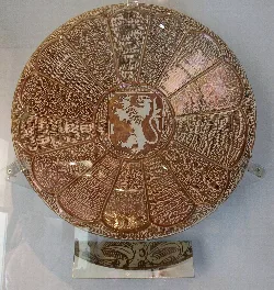 Goldener Reflex-Teller mit Wappen in der Mitte und aufwendigen Verzierungen.
