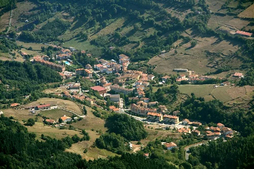 Luftaufnahme von Zegama mit Häusern und grünen Bergen.