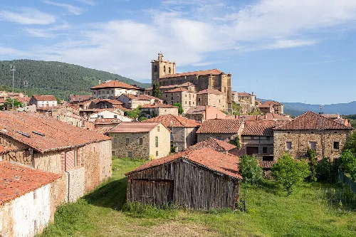Panoramablick auf Vinuesa mit Kirche auf dem Hügel und Steinhäusern.