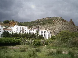 Weißes Gebäude in einer Landschaft mit Vegetation und einem Felsen in Navarra.