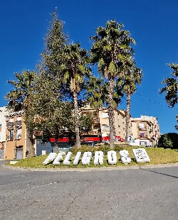 Rotonda con letras grandes que dice Peligros y palmeras en Granada.
