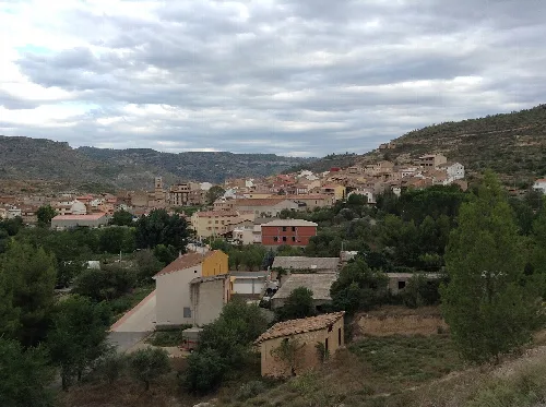 Landschaft von Casas Altas mit Häusern und Bäumen in einer bergigen Umgebung.