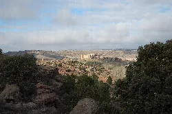 Panoramablick auf eine Burg in Sigüenza mit Bäumen und Hügeln.