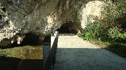 Path with railing and cave entrance in Ribadesella, Asturias.