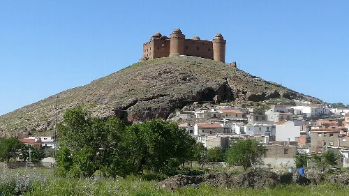 Schloss auf einem Hügel mit weißen Häusern in Granada.