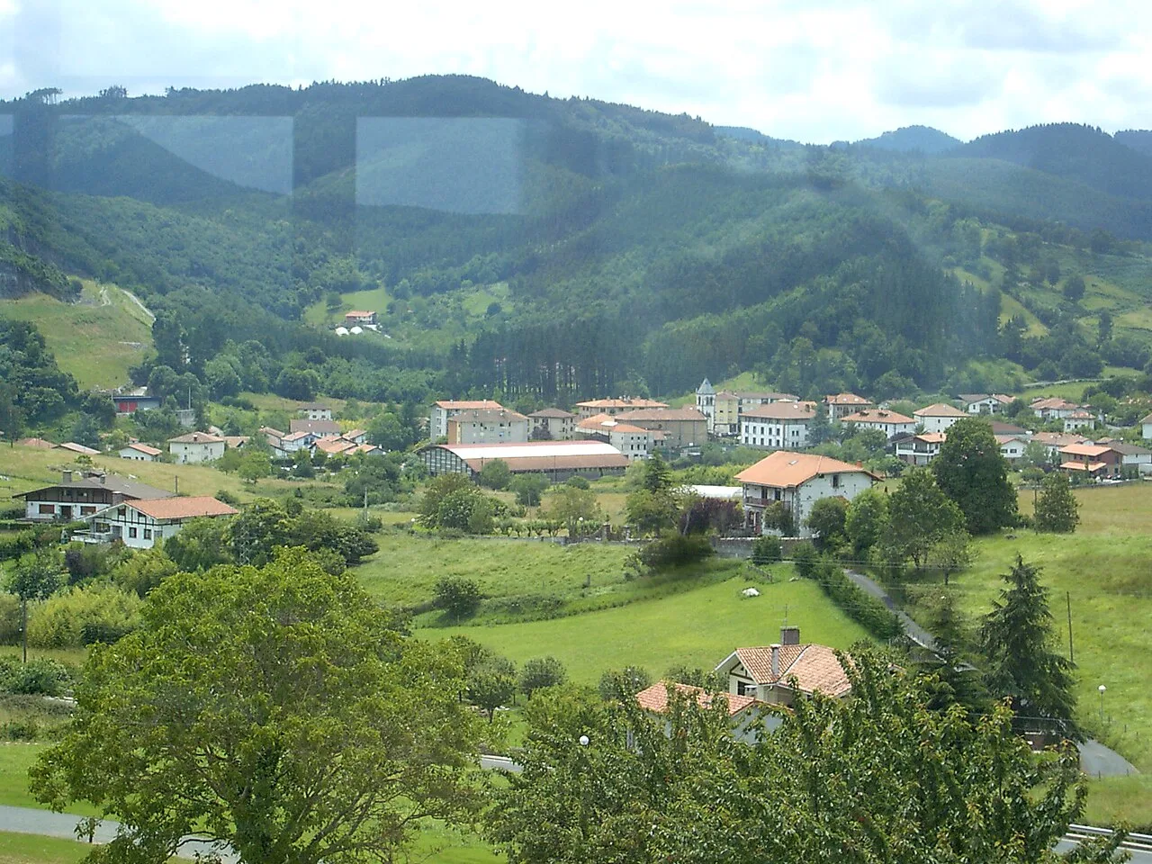 Landschaft mit Häusern und grünen Hügeln in Busturia.
