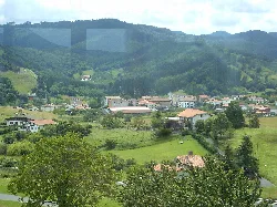 Landschaft mit Häusern und grünen Hügeln in Busturia.