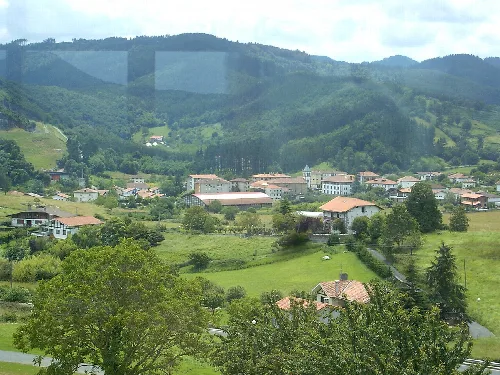 Paisaje con casas y colinas verdes en Busturia.