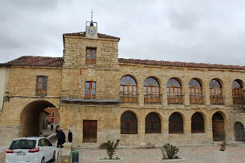 Edificio del ayuntamiento con torre del reloj y arcos en la fachada.