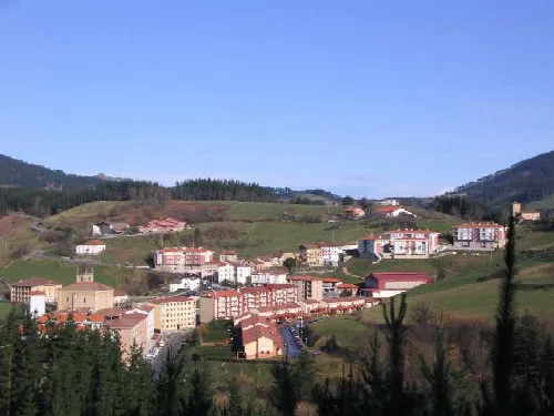 Paisaje de Mallabia con casas y montañas verdes.