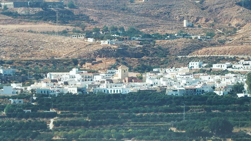 Vista aérea de casas blancas en un pueblo en un paisaje árido.
