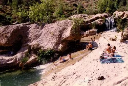 Menschen auf Felsen am Fluss mit Wasserfällen in Enguídanos