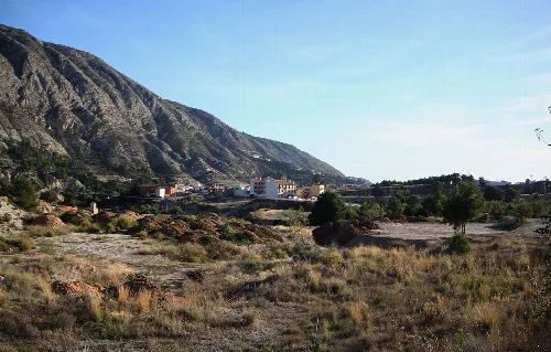 Paisaje con montañas y pueblo en un valle.