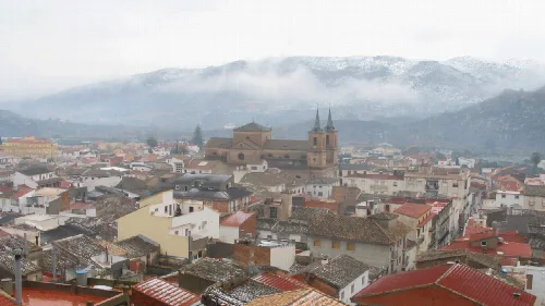 Vista de los tejados y las iglesias en Cantoria, con montañas nevadas al fondo.