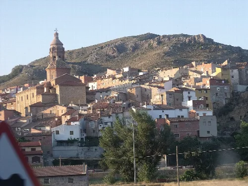 Häuser und eine Kirche an einem Hang in Oliete.
