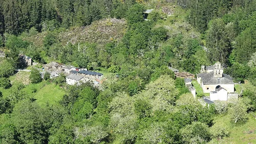 Landschaft mit Bäumen, Häusern und einem Fluss in Ribera de Piquín.