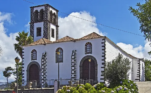 Weiße Kirche mit Turm und Vulkanstein-Details in Tacoronte.