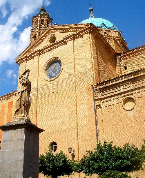 Church with blue dome and statue in the garden square in La Almunia de Doña Godina