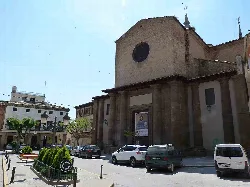 Iglesia de San Salvador en Sariñena con fachada de piedra y rosetón.