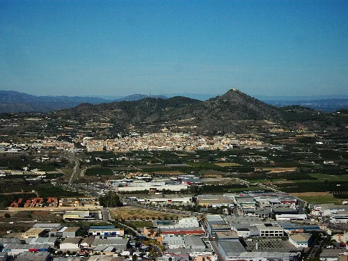 Landschaft mit Stadt, Bergen und Burg in der Ferne.