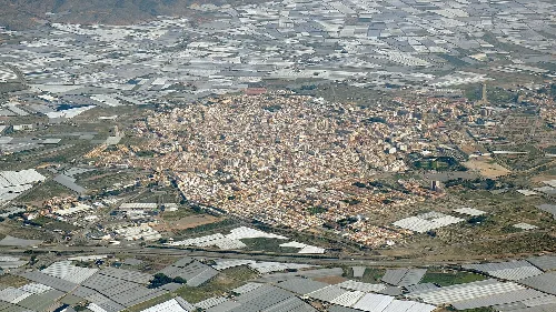 Vista aérea de El Ejido con edificios y campos agrícolas.