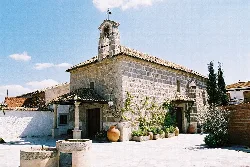 Small stone church with bell tower in Menasalbas.
