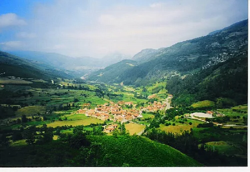 Paisaje de montaña con pueblo y valle verde en Cabuérniga