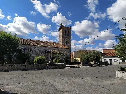 San Pedro Parish Church with stone tower and cloudy sky.