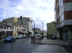 Calle en Meicende, Arteixo, con edificios y coches.