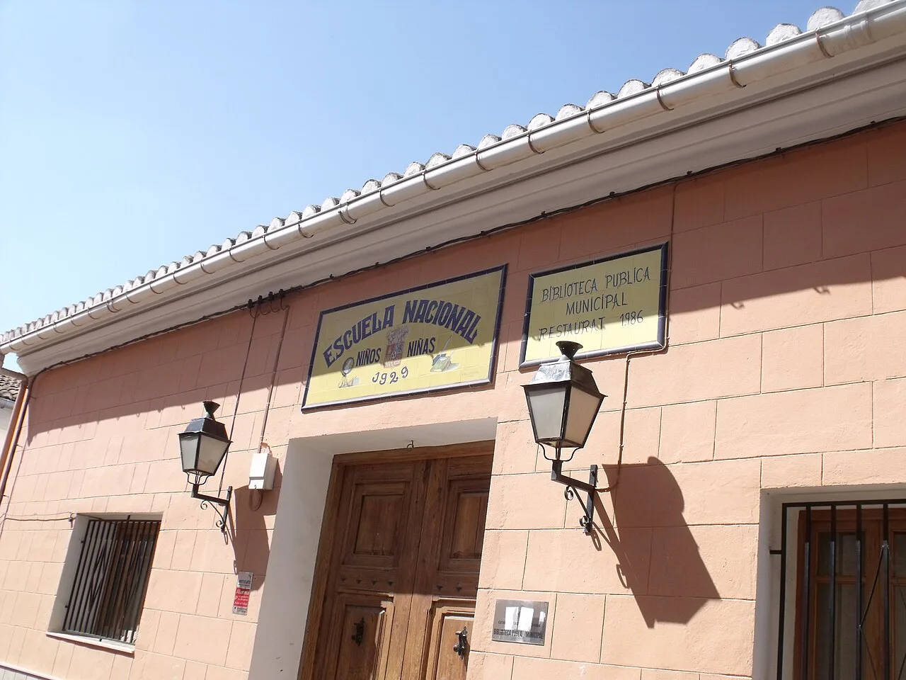 Building with signs for national school and public library in Montserrat, Valencia.