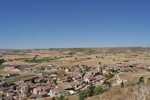 Panoramic view of Castrojeriz with houses and fields.