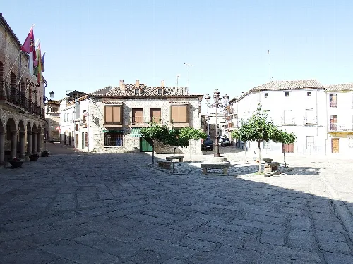 Platz mit Bäumen, Bänken und Gebäuden in Valdeverdeja, Toledo.