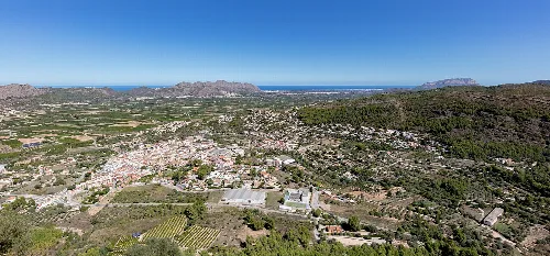 Vista aérea de Orba, con montañas y casas en el valle.