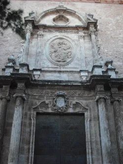 Fachada de piedra con columnas y relieve en el centro.