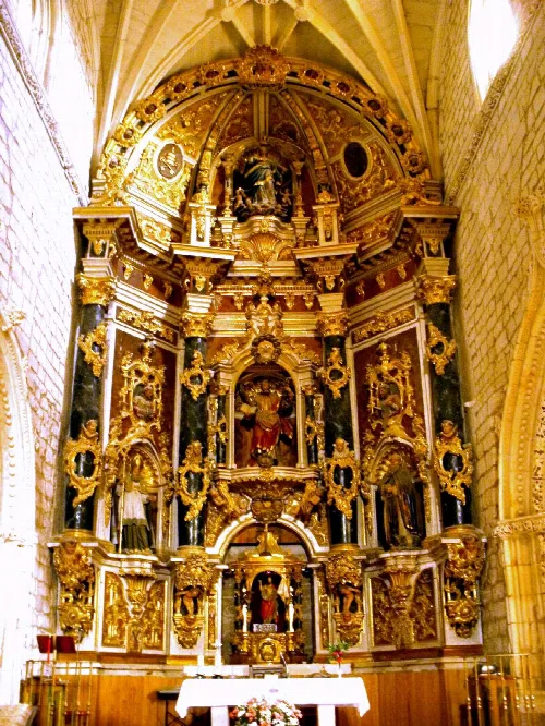 Golden altarpiece with religious figures and ornate details in San Andrés church.