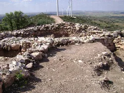 Ruinas de un castro celtibérico con molinos de viento en el fondo