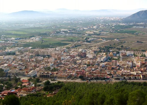 Panoramablick auf Redován vom Berg, mit Häusern und Gärten.