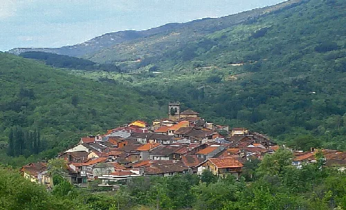 Vista del pueblo de Cepeda con casas y una iglesia en un paisaje montañoso.