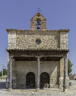 Small stone church with bell tower and wooden columns in Berlanga de Duero.